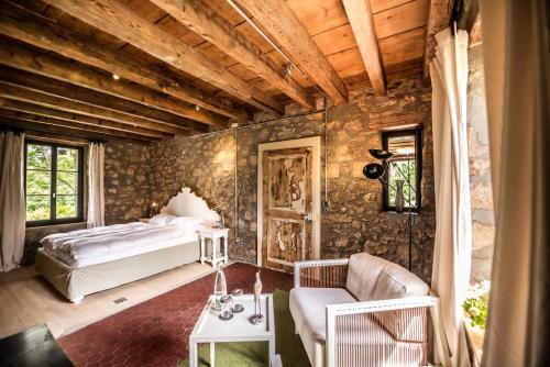 ein Schlafzimmer mit einem Bett in einer Steinmauer in der Unterkunft La Pinte du Vieux Manoir in Murten
