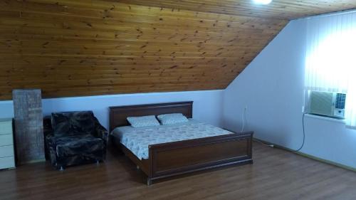 sypialnia z łóżkiem i drewnianym sufitem w obiekcie Дом-House в Vadul lui Voda w mieście Vadul lui Vodă