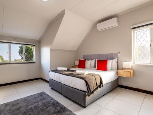 a bedroom with a large bed with red pillows at Self-Catering at Cozy Comfort in Durban