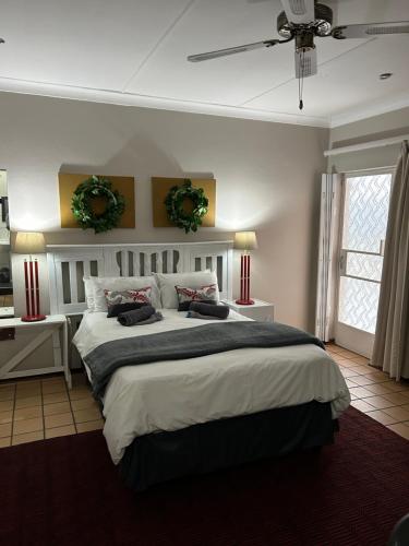 a bedroom with a large bed and a ceiling fan at Straebe Stay in Bloemfontein