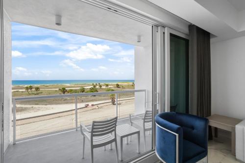 a room with a balcony with a view of the beach at Ocean Club Treasure Island Hotel in St Pete Beach
