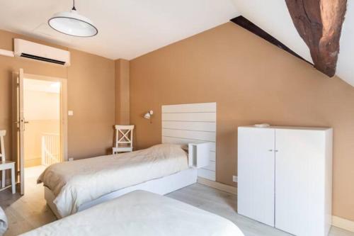 sypialnia z 2 łóżkami i białą szafką w obiekcie Le rustique Chic tout confort w mieście Châteauroux