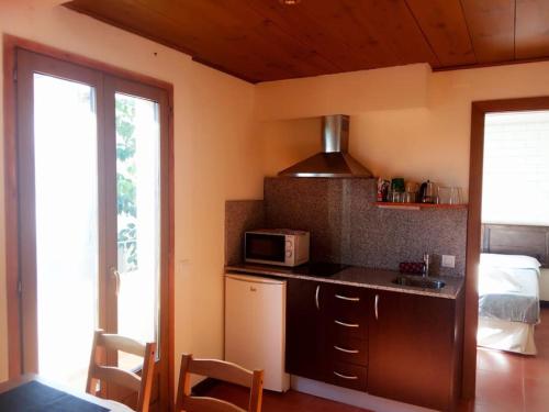 uma cozinha com um micro-ondas e uma cama num quarto em The Almond Tree em Torre del Compte