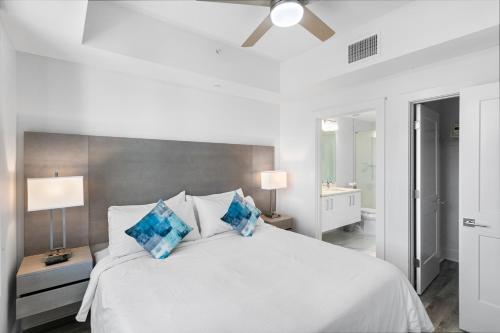 a bedroom with a white bed with blue pillows at Ocean Club Treasure Island Hotel in St Pete Beach