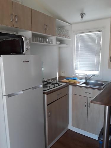 a kitchen with a white refrigerator and a sink at Complejo The Dreams in Cazalegas