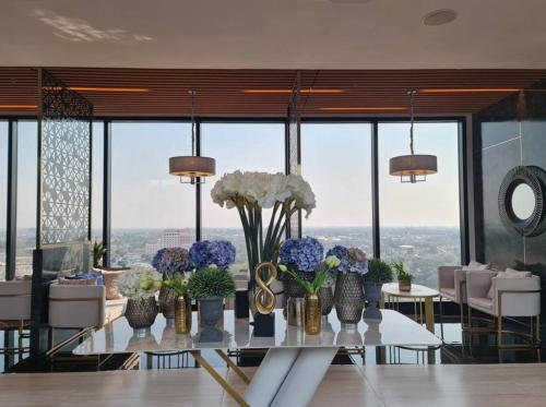 a dining room with a table with vases of flowers at The Astra Sky River in Chiang Mai