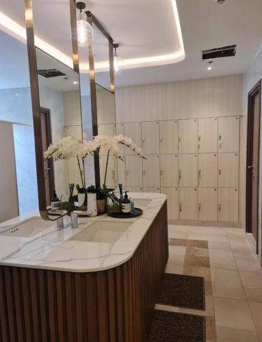 a bathroom with a large sink and a large mirror at The Astra Sky River in Chiang Mai