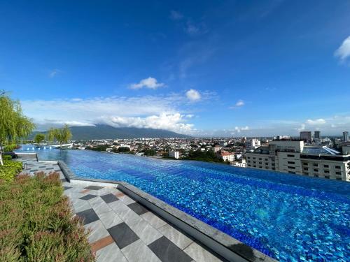 a large swimming pool with a city in the background at The Astra Sky River in Chiang Mai