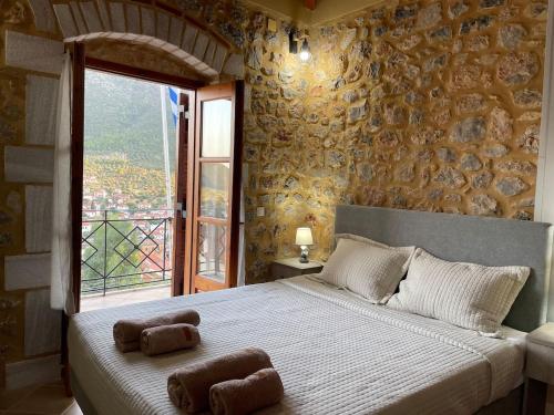 a bedroom with a large bed with two towels on it at Panorama Stonehouse in Leonidio