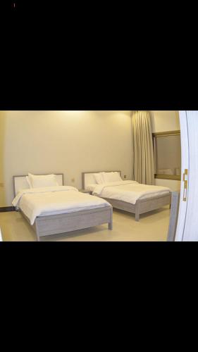 a bedroom with two beds and a mirror at شاليهات ورد المساء in Taif