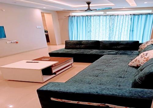 a living room with a couch and a coffee table at Staeg Hill View 2BHK - 602 in Indore