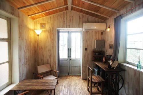 a room with wooden walls and a table and a door at Saku Cafe in Daigo