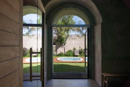 an open door to a yard with a pool outside at Dimora Cottanera in Castiglione di Sicilia