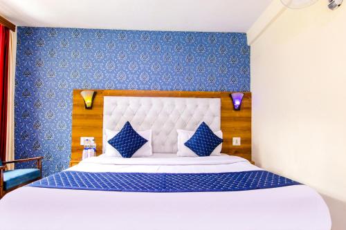 - une chambre avec un grand lit aux murs bleus dans l'établissement FabHotel Negis Shivalay, à Manali