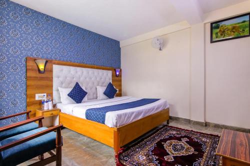 um quarto com uma cama com uma parede azul em FabHotel Negis Shivalay em Manali