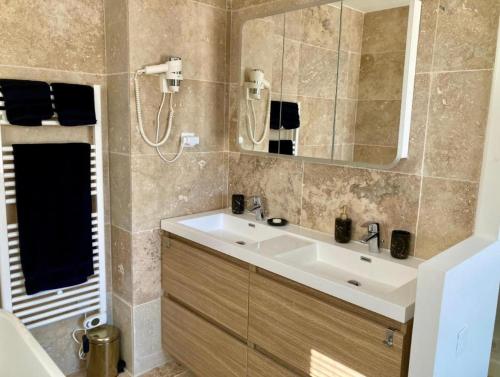une salle de bain avec un lavabo et un miroir dans l'établissement Villa Les Chênes Les Restanques du Golfe de St Tropez, à Grimaud