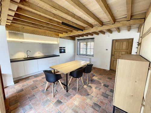 - une cuisine avec une table et des chaises en bois dans l'établissement Begijnhof 4, à Saint-Trond