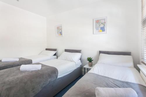 Dos camas en una habitación con paredes blancas. en Camden House - Next to Camden Market and Station - City Center, en Londres