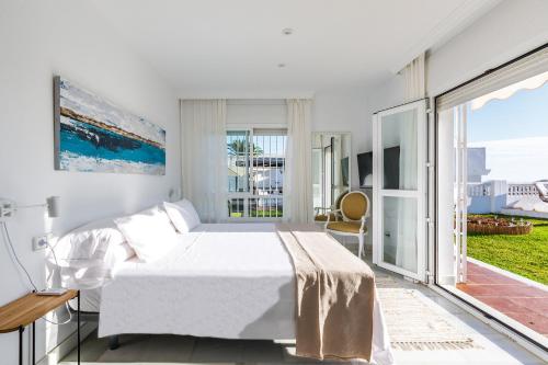 ベレス・マラガにあるA&N Rivera Casa Blancaの白いベッドルーム(ベッド1台、バルコニー付)