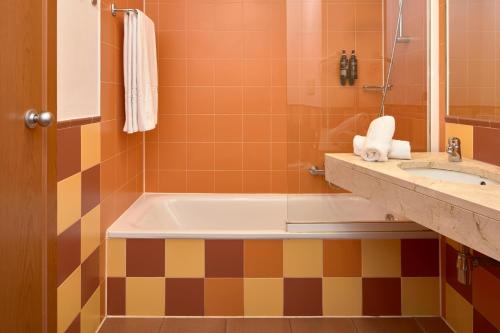 a bathroom with a tub and a sink at ALEGRIA Cabo De Gata in Retamar