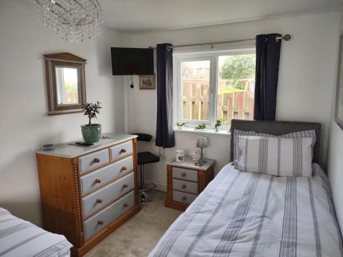 um quarto com uma cama, uma cómoda e uma janela em The Cubley Retreat em Sheffield