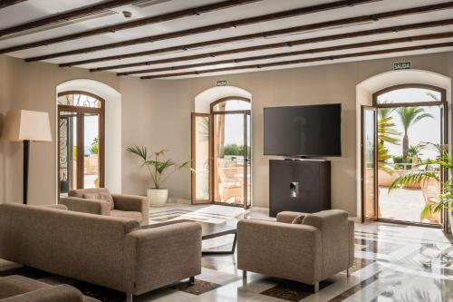 a living room with chairs and a flat screen tv at ALEGRIA Palacio Mojacar - Adults Only in Mojácar