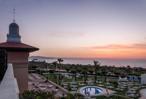 a view of the pool and the ocean at sunset at ALEGRIA Palacio Mojacar - Adults Only in Mojácar