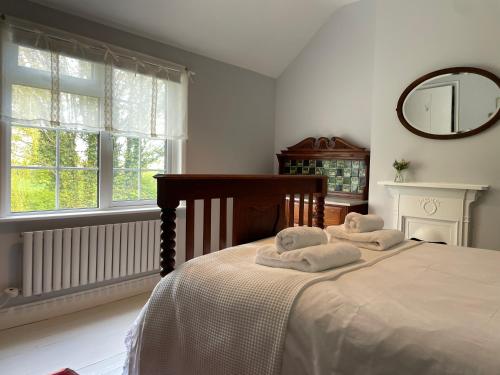 1 dormitorio con 1 cama con 2 toallas en Charming country cottage in quiet rural setting, 