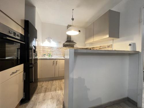a kitchen with white cabinets and a counter top at Le Cugnalais-2p- calme & confort in Cugnaux