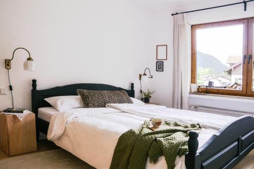 a bedroom with a bed with a green blanket on it at Servus O´gau Apartments in Oberammergau
