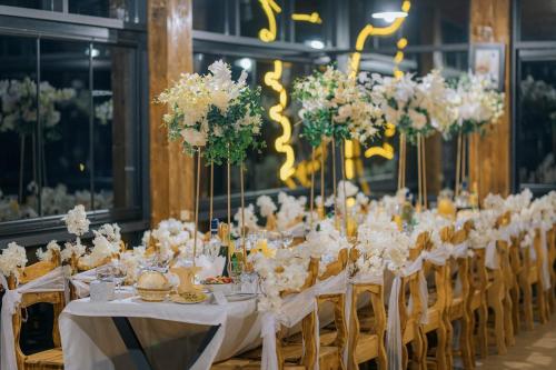 a long table with white tables and chairs with flowers at Vaio Resort in Keda in Vaio