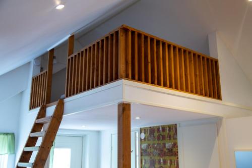 a loft bed in a room with a ladder at Ängagården - Gårdslyckan in Våxtorp