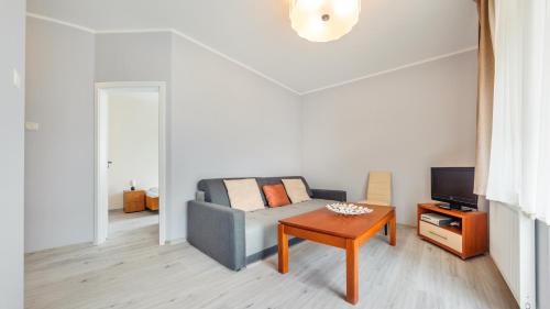 - un salon avec un canapé et une table dans l'établissement Apartamenty Sun & Snow Promenada II, à Świnoujście