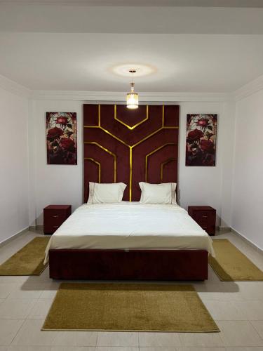 a bedroom with a large bed with a wooden headboard at Flowers home in Oujda