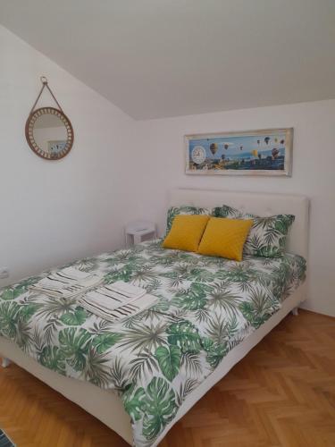 ein Schlafzimmer mit einem Bett mit einer grünen und weißen Decke in der Unterkunft Fine Rest Brcko 2 in Brčko