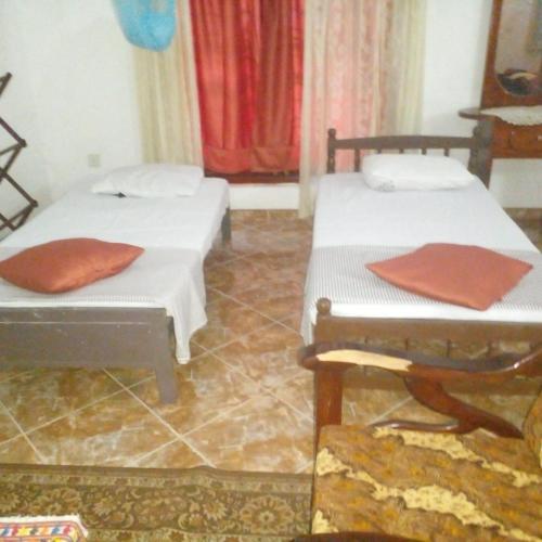 two beds sitting in a room with at Grace Villa Bentota in Bentota