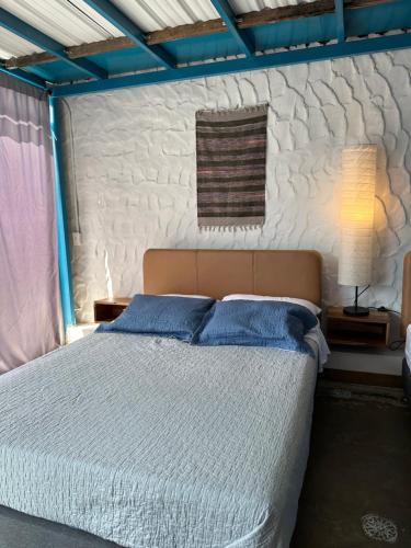 a bedroom with a large bed with blue pillows at Hotel Casa Lucca in Medellín
