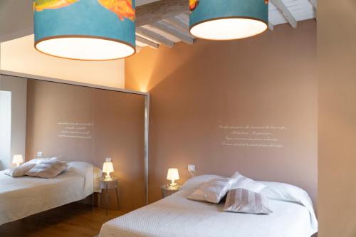 1 dormitorio con 2 camas, espejo y luces en Losanna Suites, en Campiglia Marittima