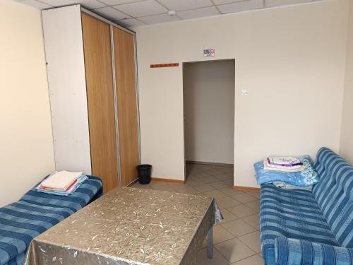 una habitación con 2 sofás azules y una mesa en Hostel WELINEK gratis parking, en Stęszew