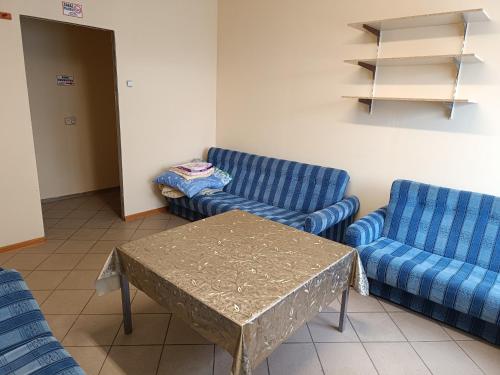 ein Wohnzimmer mit 2 blauen Stühlen und einem Tisch in der Unterkunft Hostel WELINEK gratis parking in Stęszew