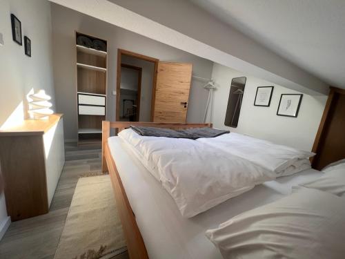 a bedroom with a large bed with white sheets at Ferienwohnung Kohl - Dachlmoos in Bischofswiesen