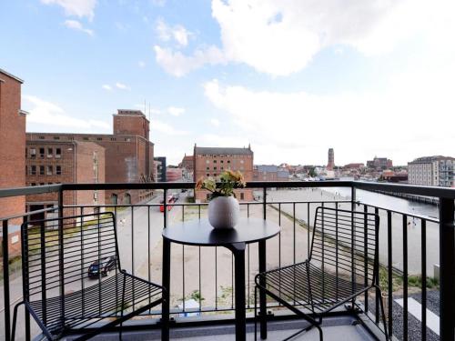 a table and chairs on a balcony with a view of a city at Ohlerich Speicher App_ 15 in Wismar