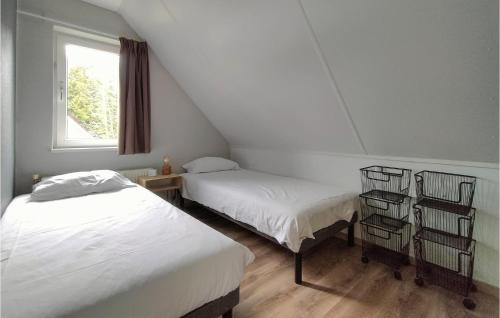 een zolderkamer met 2 bedden en een raam bij Amazing Home In Vlagtwedde With Indoor Swimming Pool And 3 Bedrooms in Vlagtwedde