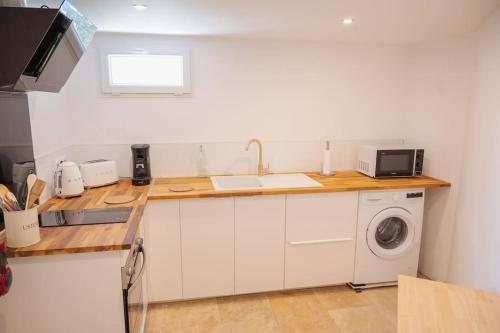 a kitchen with a sink and a washing machine at Charmant Bas de Villa au cœur de la Provence in Manosque