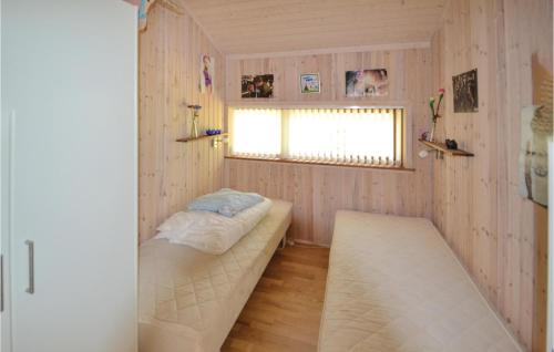 グレーノにあるStunning Home In Grenaa With 4 Bedrooms And Wifiのベッドと窓が備わる小さな客室です。