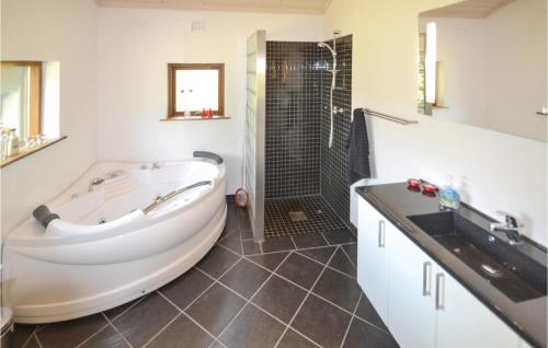 a bathroom with a large tub and a shower at Pet Friendly Home In Grenaa With Kitchen in Grenå