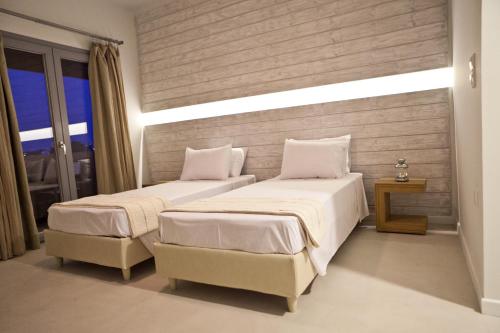 a bedroom with two beds and a window at Xanthippi Hotel in Souvala