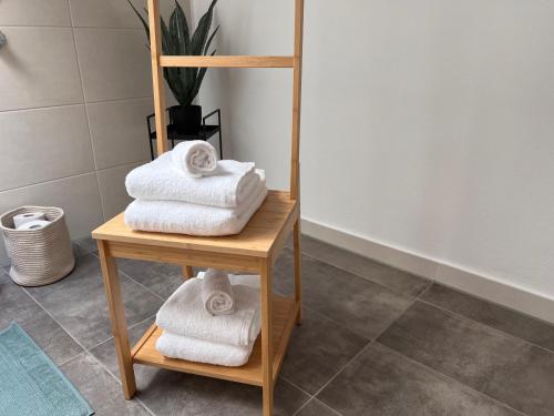 a stack of towels on a wooden shelf in a bathroom at Ferienwohnung Kohl - Dachlmoos in Bischofswiesen