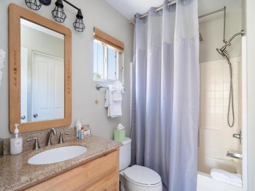 een badkamer met een wastafel, een toilet en een spiegel bij Return House in Santa Fe