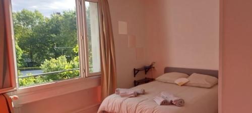 a bedroom with a bed and a large window at Neuilly-sur-Seine calme et lumineux. B&B. 3 chambres in Neuilly-sur-Seine